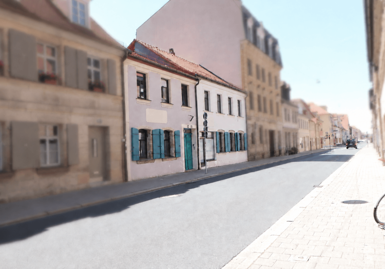 Ansicht Straße mit 2 Vordergebäuden